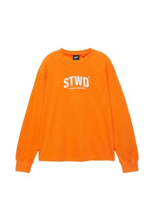 Fel oranje, lang mouwen, shirt met ronde hals en een witte "STWD"-logo met daaronder kleinere tekst "A FEELING OF BELONGING", gecentreerd op de borst.