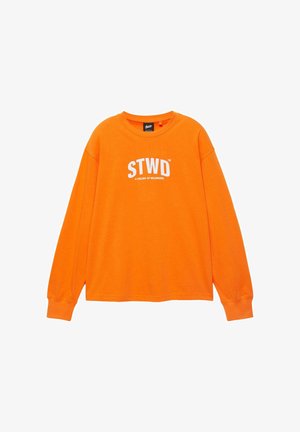 Fel oranje, lang mouwen, shirt met ronde hals en een witte "STWD"-logo met daaronder kleinere tekst "A FEELING OF BELONGING", gecentreerd op de borst.