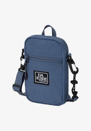 Sac bandoulière en nylon bleu de forme rectangulaire, avec des poches zippées, une sangle réglable et un patch logo noir. Texture lisse avec des détails de couture.