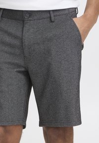 Gray, textured shorts with a straight cut, side pockets, and a button closure at the waist. Quality fabric with subtle patterns.