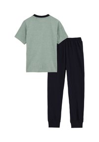 Zelené tričko s krátkym rukávom s čiernym výstrihom v kombinácii s nohavicami na elastický pás námorníckej modrej farby, vyrobené z jemnej bavlnenej látky.