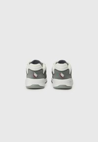 Gray and white sneakers with a smooth texture, featuring a dark blue accent, logo detail on the heel, and a rounded design.