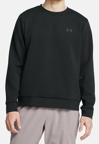 Svart sweatshirt i mjukt material, med rundad krage, långa ärmar och en liten grå logotyp på bröstet. Enkel design med avslappnad passform.