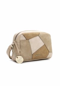 Beige geometrisk clutchväska i läder och mocka med dragkedja, med en dekorativ kedja och metallmärke.