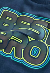 Navy sweatshirt featuring bold, glossy "BEST BRO" text with layered neon accents in green and blue. Smooth texture and ribbed neckline.