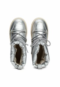 Zilveren metallic laarzen met ronde neuzen, gewatteerde kraag en grijze veters. Voorzien van een textuurstof en een crème zool.