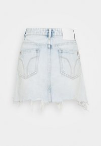 Jeanskjol i ljusblått med fransad fåll, med två bakfickor och en vit etikett vid midjan. Slät yta, avslappnad design.