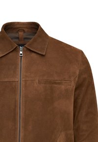 Bruine suède jas met een rits aan de voorkant, puntige kraag en een borstzak. Gladde textuur en minimalistisch ontwerp zonder zichtbare patronen.