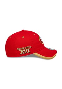 Červená čiapka s zakriveným okrajom, so zlatou výšivkou s nápisom "SUPER BOWL XVI" na boku. Logo nášivka zobrazená na prednej strane.