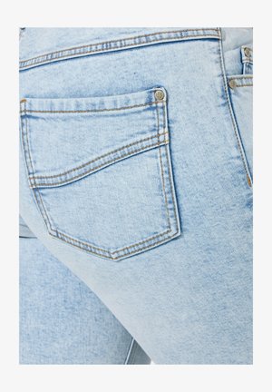Hellblaue Jeans aus Denim mit einer Gesäßtasche, die kontrastierenden Nähten und einem metallenen Knopfdetail versehen ist. Der Stoff hat eine leicht strukturierte Optik.