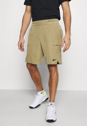 Pantaloncini color sabbia con due tasche cargo, tessuto leggero, cintura elastica e un piccolo logo Nike nero sull'orlo sinistro.
