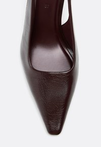 Scarpa con tacco alto bordeaux, con punta affusolata e materiale sintetico lucido e strutturato. Taglia 37 indicata all'interno.