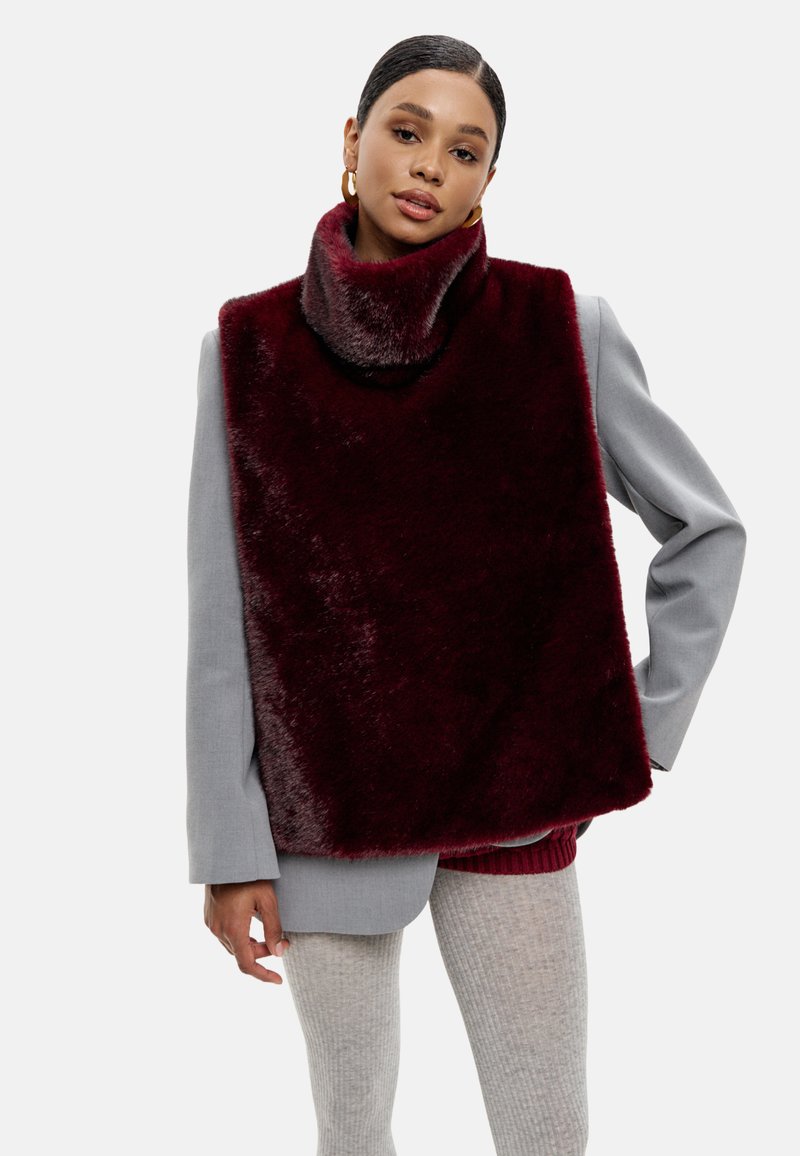 Burgundské umělé kožešinové nákrčník s širokým límcem, přes šedý blazer. Obsahuje hladkou texturu a obdélníkový tvar.