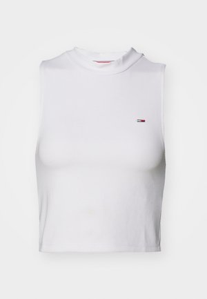 Hvit cropped tank topp med høy hals, laget av myk bomull, med en liten klassisk logo på venstre bryst. Minimalistisk design.