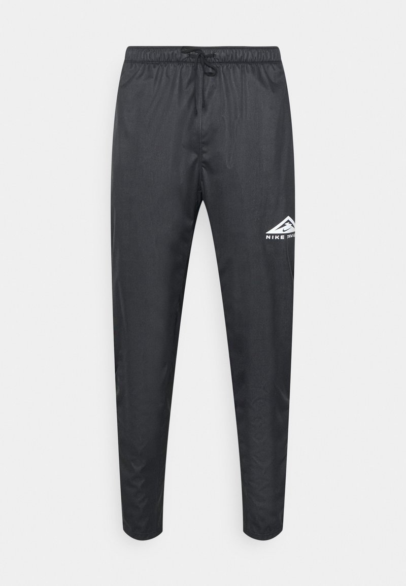 Pantalon de sport noir avec taille élastique et cordon, jambes fuselées, et un petit logo blanc Nike Trail sur la partie supérieure de la cuisse gauche.