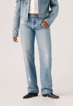 Jeans in denim azzurro chiaro con motivi paisley ricamati e borchie lungo i lati. Presentano una vestibilità comoda e un classico design a cinque tasche.