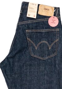 Donkerblauwe denim jeans met een regular straight cut, voorzien van contrasterende stiksels, een leren label en een 'Made in Japan' label.