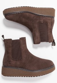 Botas de tobillo de ante marrón con paneles laterales elásticos, suelas de goma texturizadas y una lengüeta en la parte trasera para un acceso fácil.