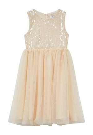 Jong meisje met krullend haar draagt een mouwloze beige jurk met een lijfje met pailletten en een tule rok, staand tegen een effen witte achtergrond.