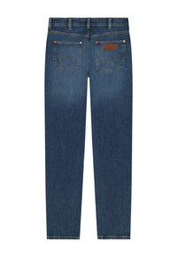 Back view of blue denim jeans with two back pockets, belt loops, and a small brown leather brand patch on the right pocket.