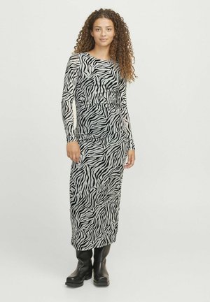 Haljina dugih rukava, priljubljena, s crno-belim uzorkom zebra, izrađena od glatkog materijala, s okruglim izrezom i dužinom do gležnjeva.