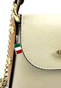 Crème leren handtas met gouden hardware en kettingband, met een klein Italiaans vlaggetje charm dat aan de sluiting is bevestigd.