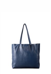 Navy blue leather tote bag with two handles, featuring a square logo patch and a textured finish. Open top and spacious interior.