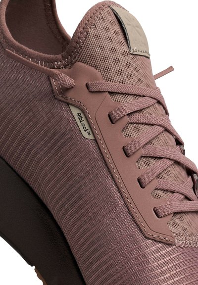 Sportliche Schuhe in gedämpftem Mauve mit einem strukturierten Mesh-Obermaterial, glatten Lederausschnitten und gerippten Details an der Seite. Mit klassischen Schnürsenkeln ausgestattet.