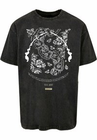 Juoda per didelėc t-shirt pagaminta iš medvilnės, su baltais gėlių ir veido grafikos dizainais priekyje, siuvimo detalėmis ir etiketėmis apačioje.