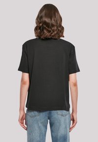 Black oversized t-shirt with a round neckline and short sleeves, featuring a smooth texture and a relaxed, straight fit at the hem.