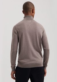Slim fit, visoki pulover s okruglim izrezom u svijetlo sivoj boji, izrađen od mekanog materijala s rebrastim manžetama i rubom, glatke teksture, dizajniran za prilagođen izgled.