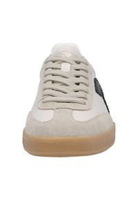Beige sneaker med överdel i mocka och läder, platta snören, gummisula, svart accent på sidan och strukturerad patch nära hälen.