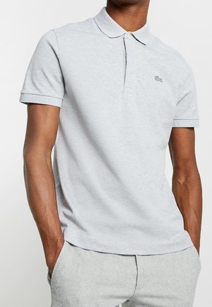 Jasnoszara koszulka polo o miękkiej fakturze, z krótkimi rękawami i małym haftowanym logo na piersi. Posiada klasyczny kołnierzyk i zapięcie na guziki.