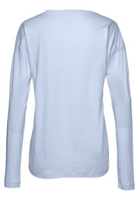Långärmad skjorta i ljusblå bomull. Har rund halsringning och avslappnad passform. Mjuk textur utan mönster eller dekorationer.