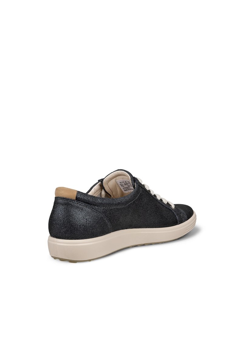 Zapatillas negras brillantes con perfil bajo, cordones blancos y suelas de goma beige. Textura suave, con un acento beige en el talón.