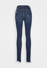 Tajta jeans i mörkblå denim. Har hög midja, två bakfickor och råa kantdetaljer. Materialet verkar slätt med subtila slitningar.