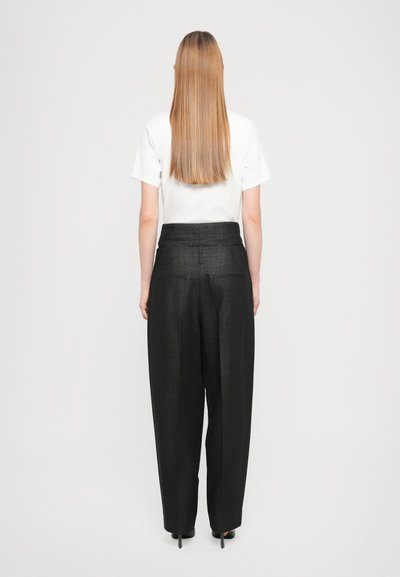 Black, textured high-waisted trousers with a loose fit, paired with a white t-shirt. Visible back pockets and straight leg design.