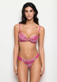 Różowy zestaw bikini z wzorzystym stanikiem na fiszbinach i szczegółem w formie skrętu, pasującym do niskich majtek o podobnym falistym wzorze i gładkiej fakturze.