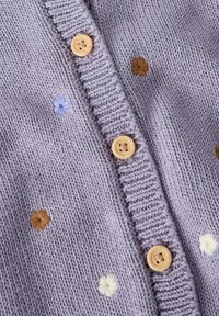 Lila gebreid vest met ronde houten knopen, voorzien van geborduurde bloemaccenten in bruin, lichtblauw en wit. Gestructureerde stof.