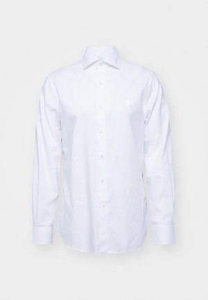 Weißes Hemd mit Knöpfen aus Baumwolle. Merkmale sind lange Ärmel, ein spitzer Kragen und ein kleines besticktes Logo auf der Brust. Glatte Textur.