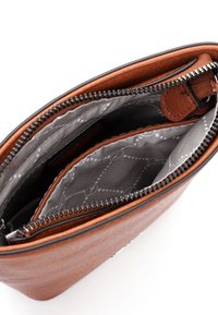 Brun lædertaske med en lynlåsåbning, der viser en struktureret overflade. Indvendigt har den grå foret med cirkulære mønstre og flere lommer.