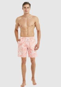 Costumi da bagno da uomo in corallo chiaro con un motivo a foglia tropicale bianca, dotati di una vita elasticizzata e cordoncino, realizzati in un tessuto leggero.