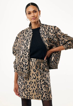 Blouson bomber en imprimé léopard doré et noir, assorti d'une jupe. Tissu texturé avec des poignets et une taille élastiques.