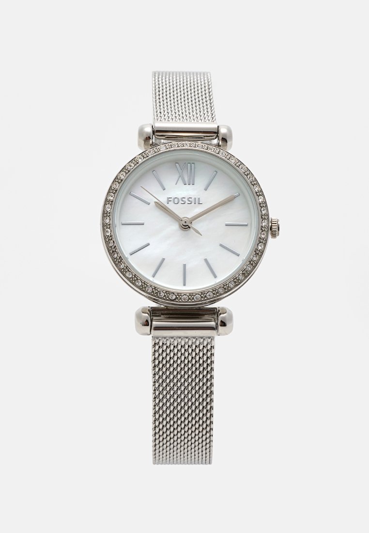 Orologio Fossil argento con quadrante rotondo in madreperla, ghiera in cristallo e cinturino a rete. Presenta numeri romani e un design minimalista.