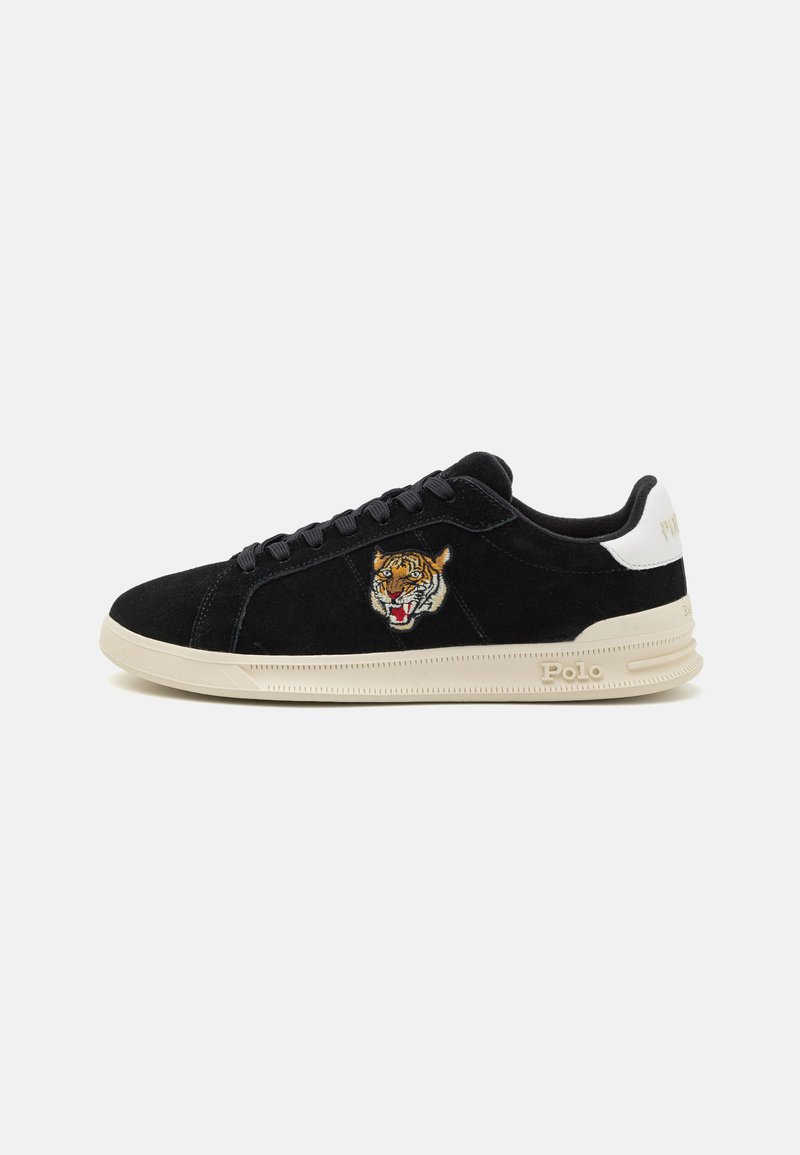 Schwarze Wildleder-Sneaker mit beiger Sohle, weißem Fersenpatch, besticktem Tigerkopf an der Seite und "Polo"-Schriftzug auf der Sohle nahe der Ferse.