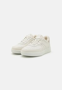 Vita sneakers med slät syntetmaterial, rund tå, perforerad detaljering på sidorna och gummisula. Snörningsdesign med foder i tyg.