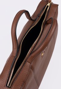 Borsa a mano in pelle marrone con finitura testurizzata, chiusura con cerniera dorata e doppio manico. Interno nero. Presenta un dettaglio logo minimalista.