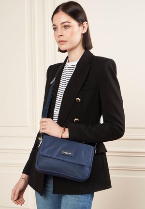 Sac en bandoulière bleu marine en nylon lisse, doté d'une fermeture à rabat, d'une sangle réglable et d'un détail de logo.
