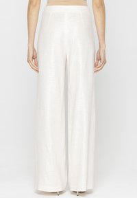 Szerokie spodnie o jasnobe�żowym materiale z teksturowanym wykończeniem, z wysokim stanem i prostym krojem.