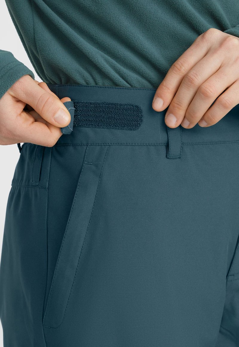 Lichtgewicht teal broek met textuurstof, verstelbare klittenband tailleband, zijzakken en subtiele stikdetails.